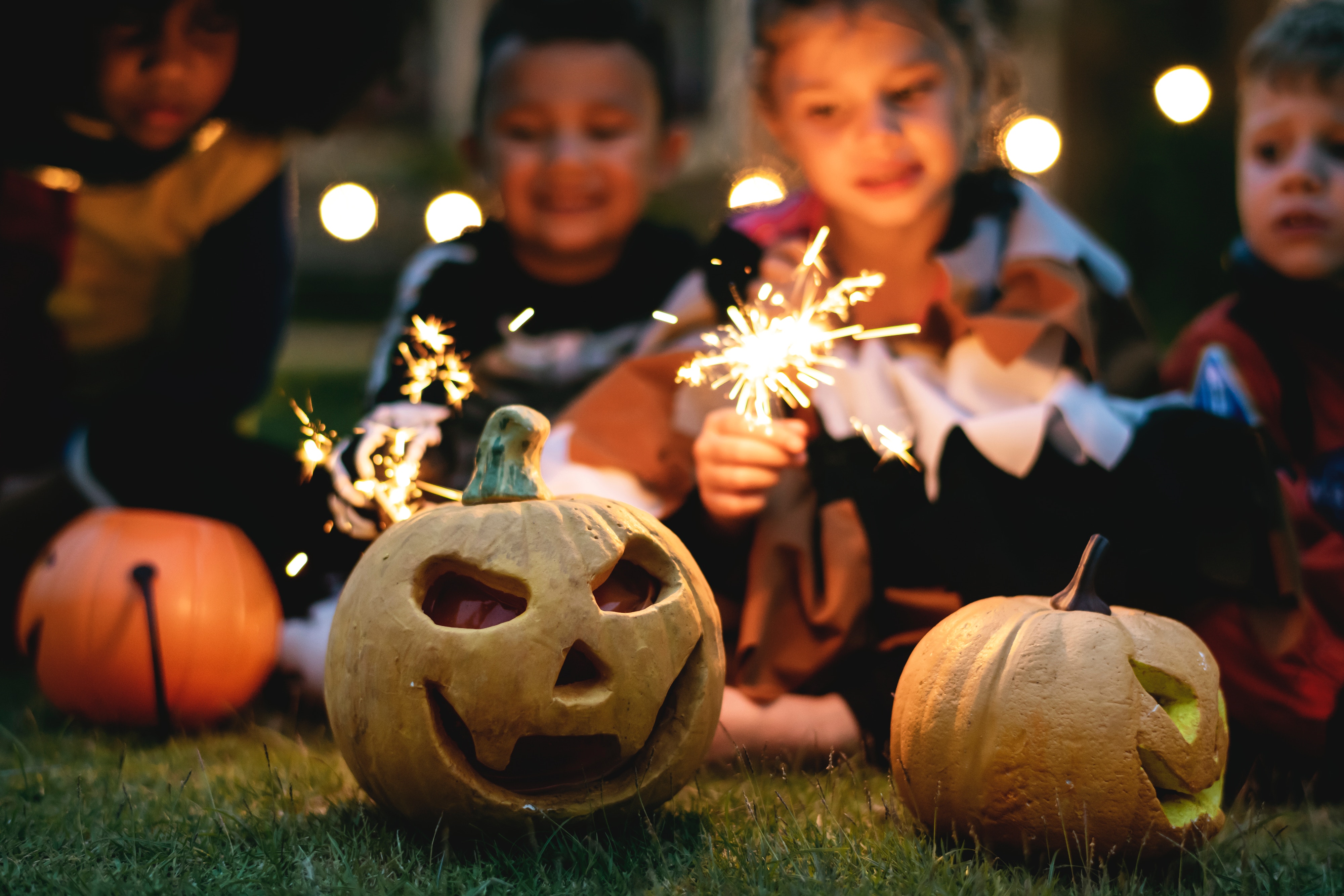 children with sparklies and jack o' lanterns on Halloween