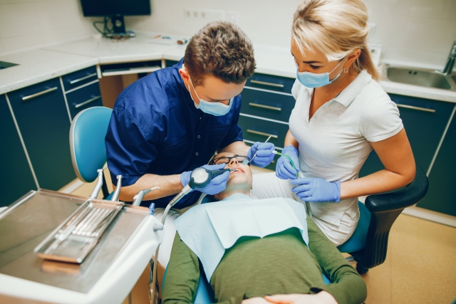dentist, dental assistant and patient in a clinic