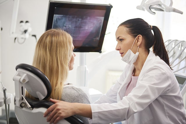 dentist talking to woman during dental checkup